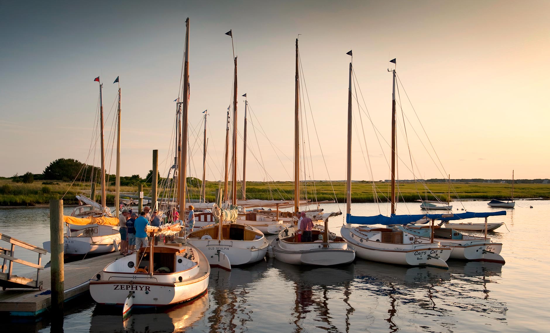 A gathering of catboats at dusk at West Dennis , MA