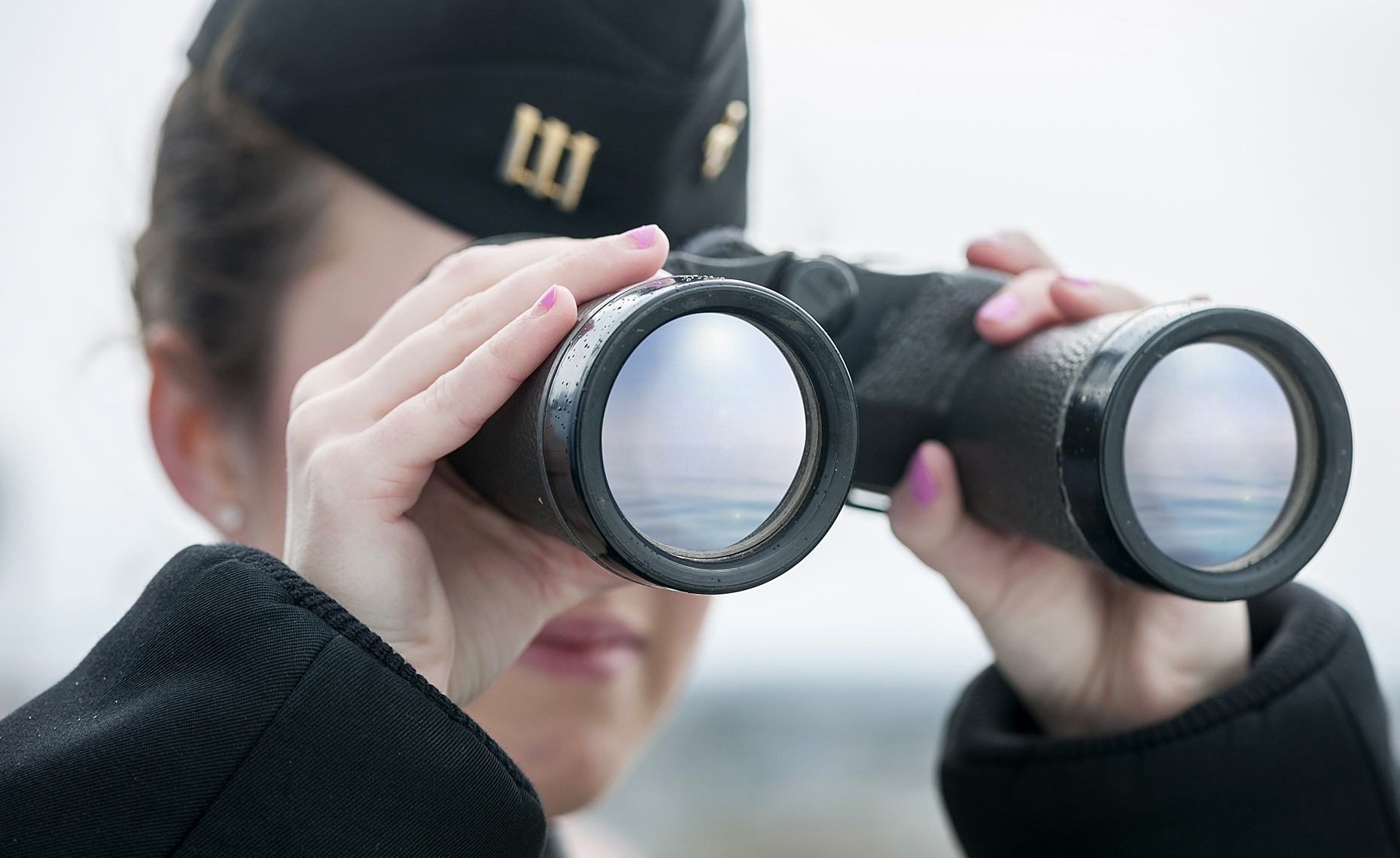 Close up of Binoculars being held by female cadet from Mass Maritime Academy