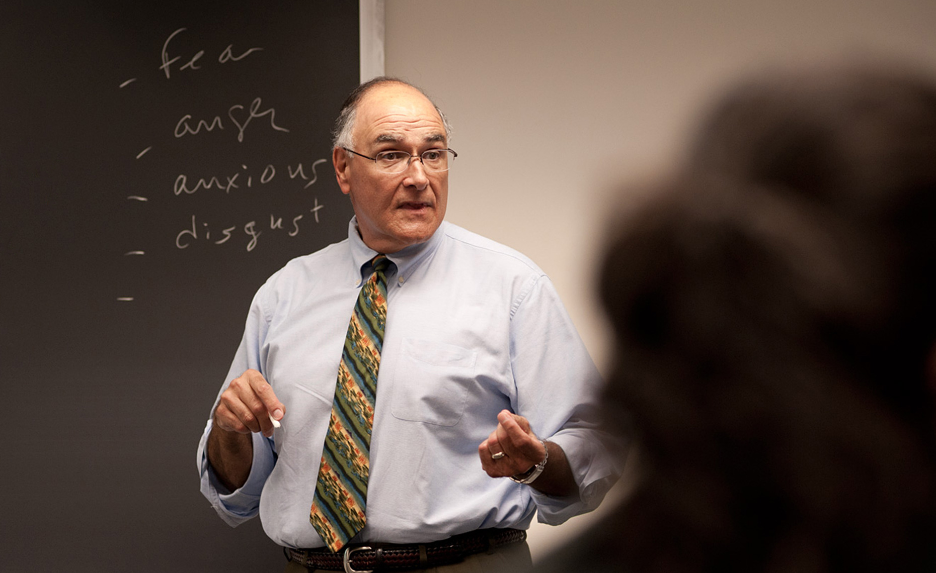 male professor lecturing at chalkboard at Bentley University