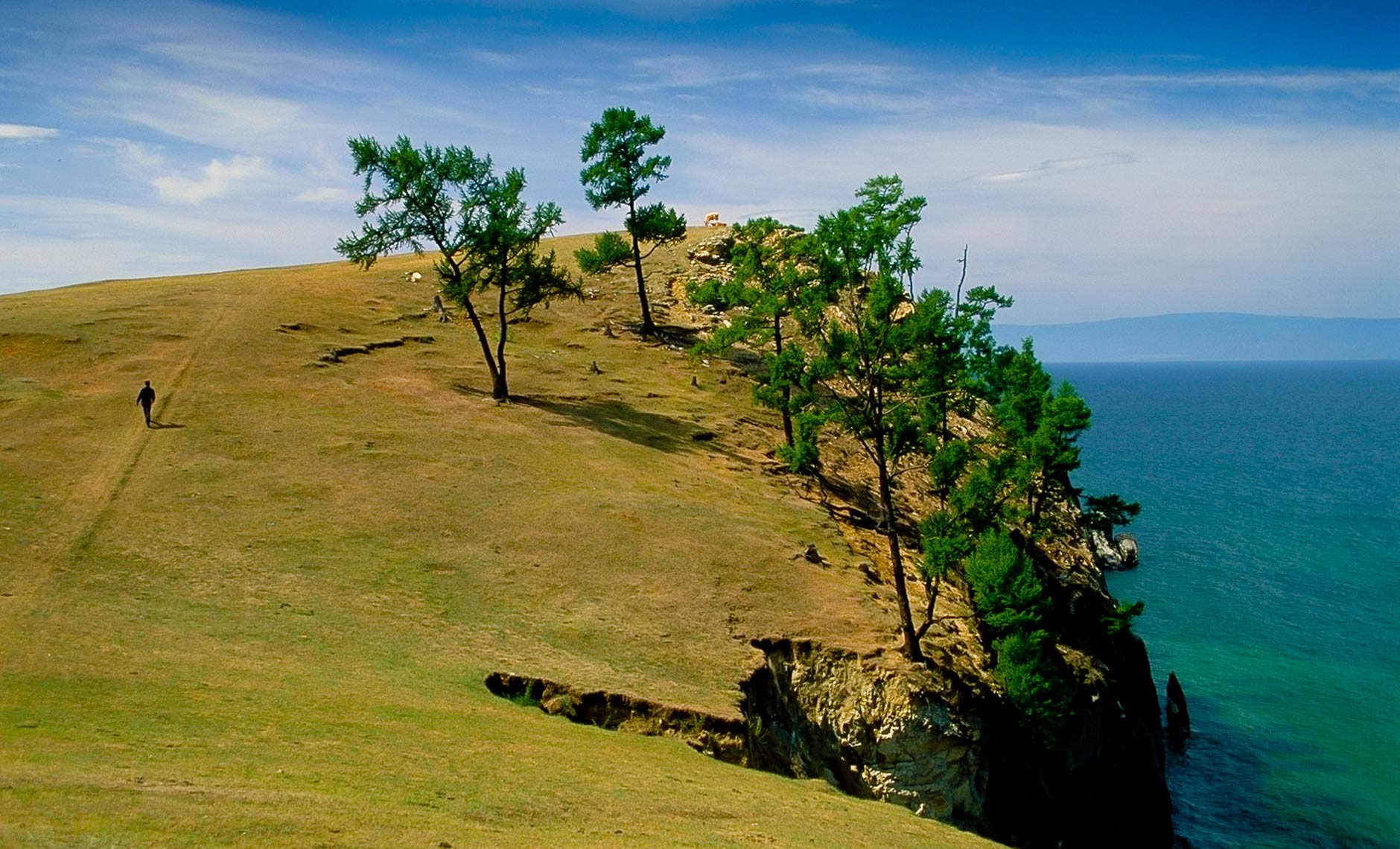 man walking up hillside near Lake Baikal, Russia