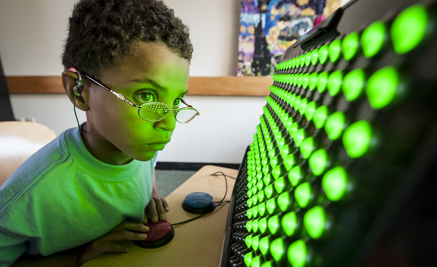 Young male child playing with light game at Perkins school for the Blind